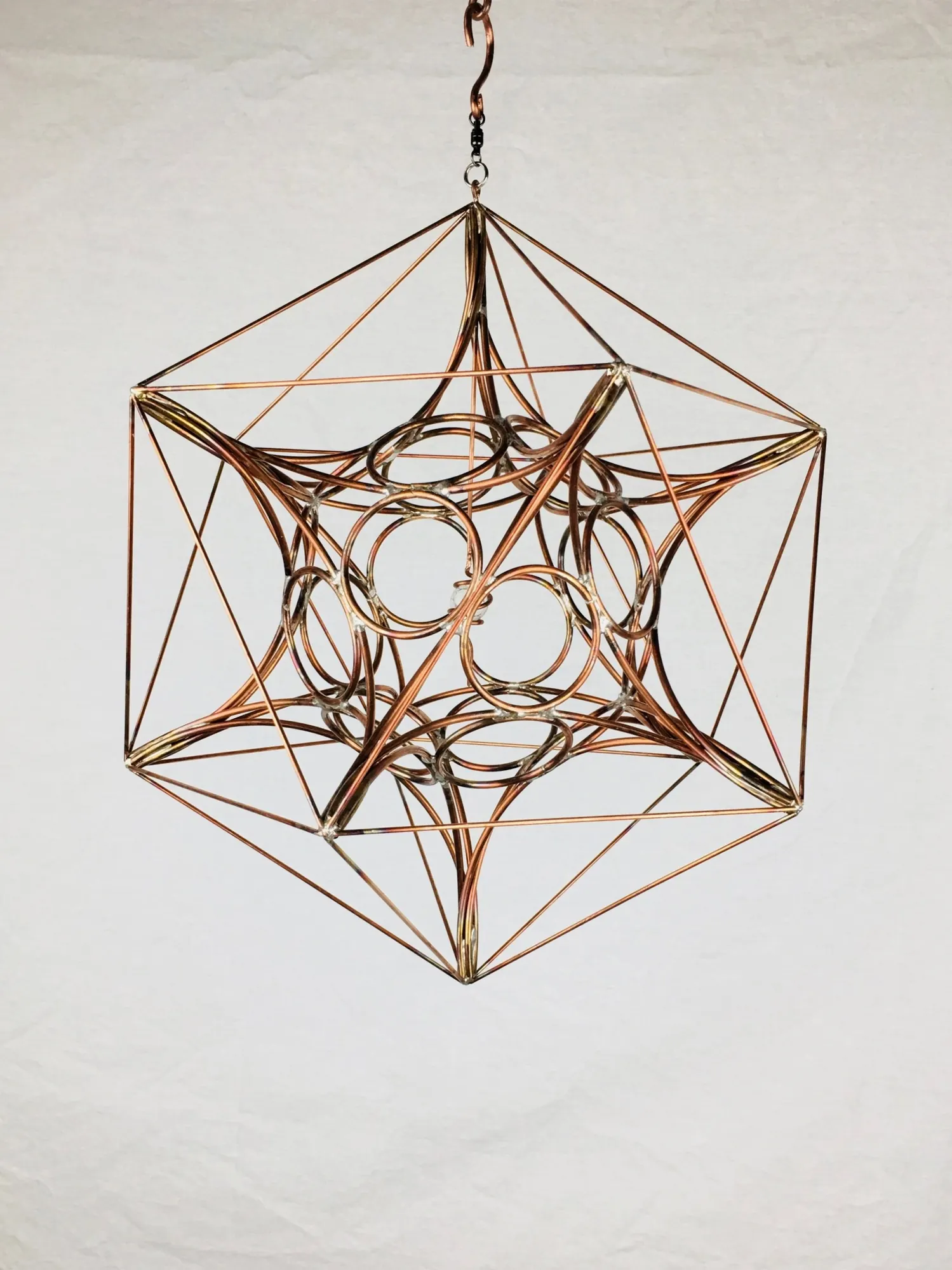 IcosaSphyr: a hanging copper sculpture of intersecting rings within an icosahedral wire frame
